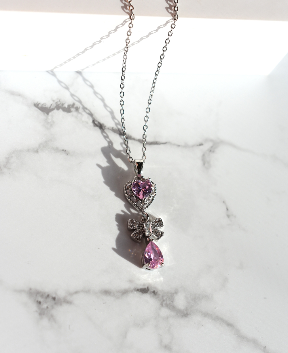 Γυναικείο Κολιέ Καρδιά με Φιόγκο και Σταγόνα από Ανοξείδωτο Ατσάλι με Μωβ Ζιργκόν – Ασημί