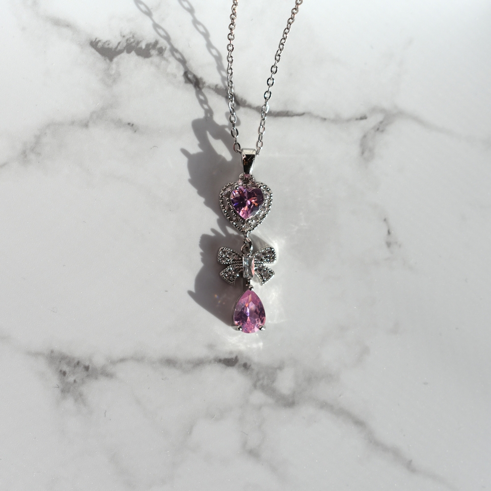 Γυναικείο Κολιέ Καρδιά με Φιόγκο και Σταγόνα από Ανοξείδωτο Ατσάλι με Μωβ Ζιργκόν – Ασημί